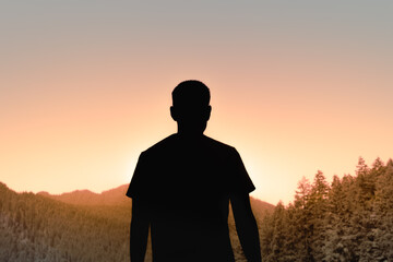 silhouette of a man in sunset looking out to the mountain sunset  feeling at peace, calm in nature 