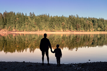 Father and son holding hands spending time together outdoors, fatherhood, parenting concept 