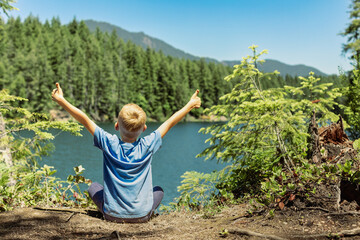 Happy child in nature forest thumbs up, summer travel concept 