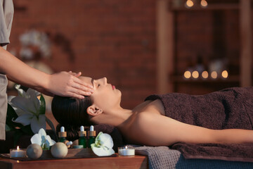 Obraz na płótnie Canvas Young woman getting massage in dark spa salon, closeup