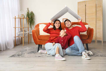 Obraz premium Happy family with cardboard dreaming about their new house in living room