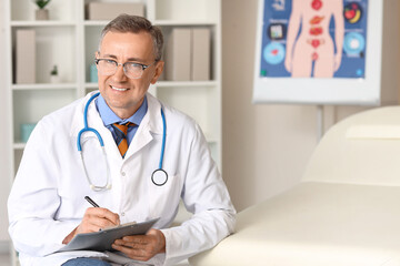 Mature doctor with clipboard in medical office