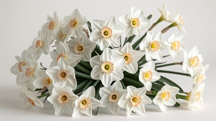   White flowers sit atop a pristine table, adjacent to a vase brimming with white and yellow blooms
