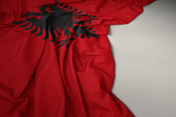 waving national flag of albania on a gray background.