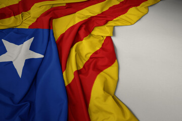 waving national flag of catalonia on a gray background.