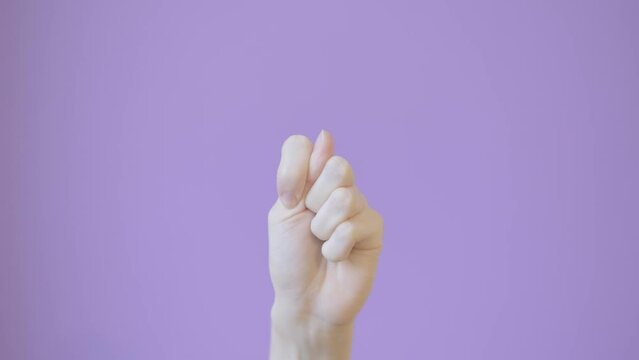 Close up woman hand shows fig sign isolated on lilac background. Fig gesture