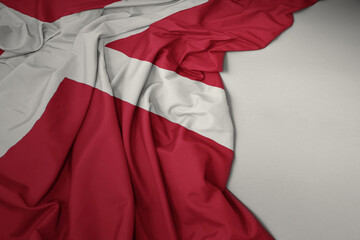 waving national flag of denmark on a gray background.