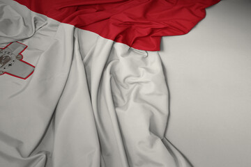 waving national flag of malta on a gray background.
