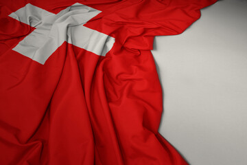 waving national flag of switzerland on a gray background.