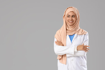 Female Muslim medical intern on light background