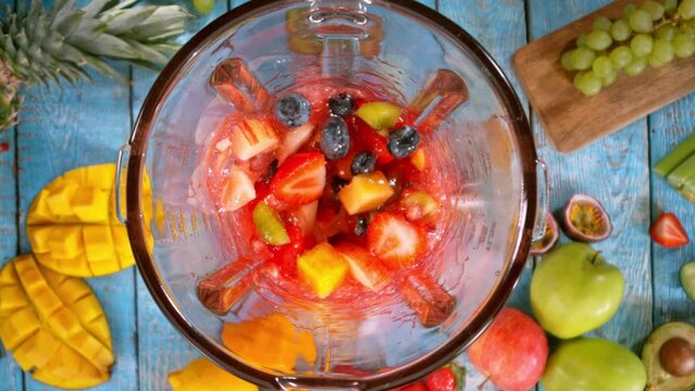 Super Slow Motion of Mixing Fruit Pieces into Blender. Camera Moving Up. Filmed on High Speed Cinema Camera, 1000 fps. Speed Ramp Effect.
