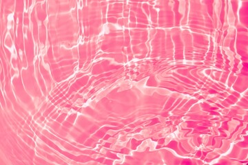 Pink transparent clear calm water surface texture. Natural ripple water surface on pink background...