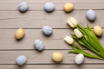Beautiful tulip flowers and Easter eggs on grey wooden background