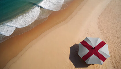 An aerial vista of a sandy beach with gentle ocean waves, featuring a beach umbrella adorned with the Alabama flag. Ideal for Alabama tourists seeking seaside relaxation