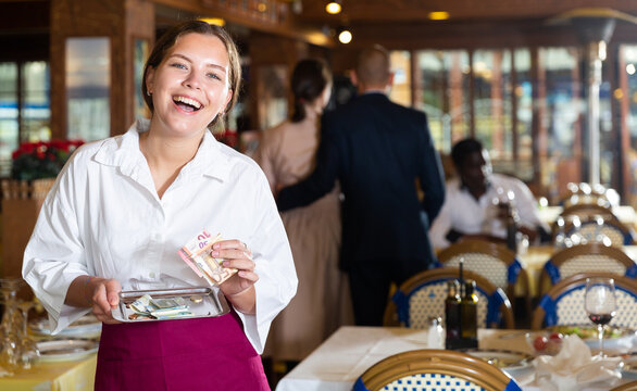 Happy waiter got a good tip from restaurant patrons