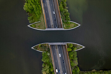 Highway with traffic passing underneath Veluwemeer aquaduct seen from above. Top down aerial...