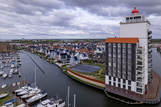 Light house apartment building in Dutch waterway residential neighbourhood. Aerial of De Knar recreational port at the Veluwemeer with pleasure boats. 