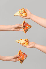 Many hands holding pizza slices on white background