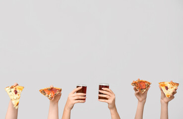 Many hands holding pizza slices and can of soda on white background
