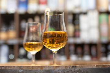 Whisky glass close-up on colorful blurred background on oak barrel