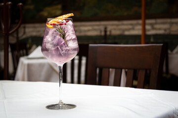 Ginebra gin en una copa de vidrio sobre mesa blanca dentro de restaurante.