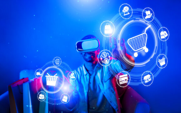 Happy man using VR headset and shopping online while sitting at sofa with shopping bags. Smart person looking at online market hologram and icon with neon background. Innovation technology. Deviation.