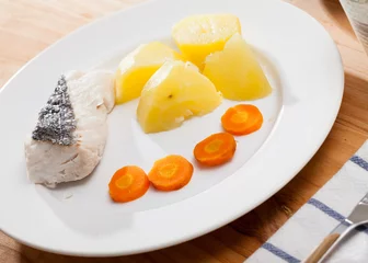 Gordijnen Closeup of codfish prepared on steam with potatoes and carrots at plate © JackF