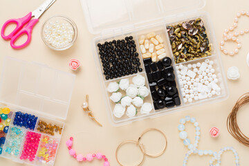 Tools and beads for making handmade jewelry on color background, top view