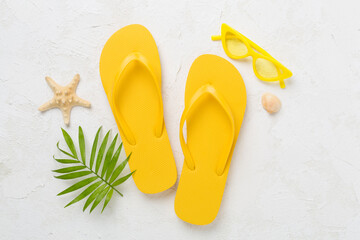 Bright yellow flip-flops on concrete background, top view. Summer concept