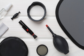 Different camera cleaning tools on wooden background, top view