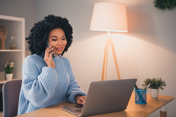 Portrait of pretty young lady wear sweater chatting telephone laptop desk home office indoors