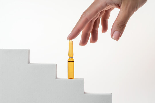 Hand reaching for Aloe extract serum ampoule on steps