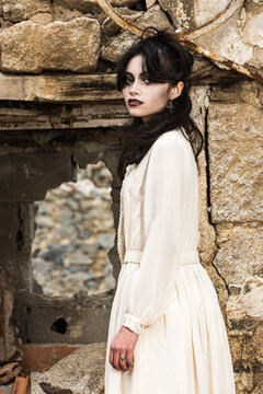 Mysterious woman in vintage attire by ruin
