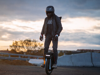 A man rides on an electric unicycle. Mono Wheel riding (EUC) , protective gear , helmet and gloves