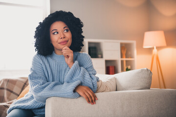 Photo of pretty young woman sit couch contemplate wear sweater modern interior apartment indoors