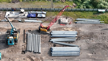 aerial view of construction site, spun piles, tractors, pulleys and large construction equipment. - obrazy, fototapety, plakaty