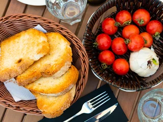 Outdoor kussens Crispy toasted white bread slices, fresh ripe tomatoes and garlic served on plates. Ingredients for traditional Catalan tapas Pan con tomate © JackF
