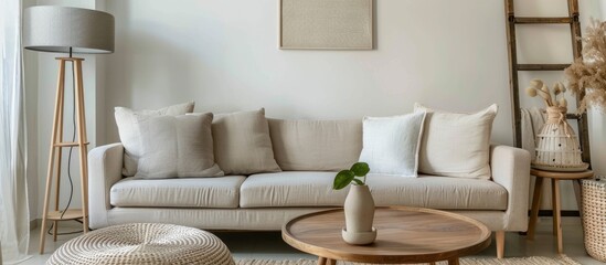 Sophisticated living room interior with a gray lamp positioned above a beige couch, accompanied by a ladder and a wooden round table.