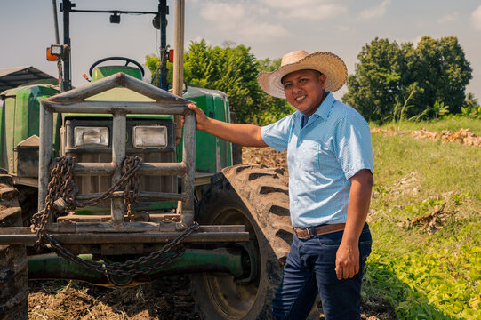 Portrait of farmer smiling at camera in front of his tractor.