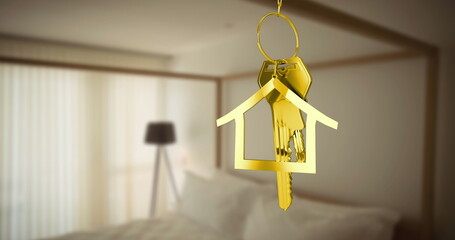 Golden house-shaped keychain with keys hanging in bedroom