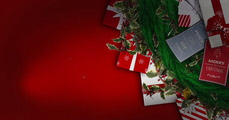 A Christmas wreath and gifts with tags lie on red background - 788804547