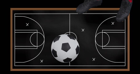 Person wearing soccer shoes standing on chalkboard with a soccer field drawn on it - 788804586