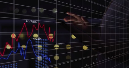 A person wearing dark outfit pointing at a digital graph showing market trends - 788804596