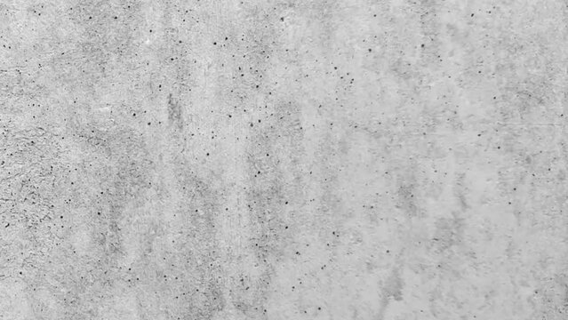 Zoom-in footage of a seamless gray concrete surface with black dots. Concrete surface background