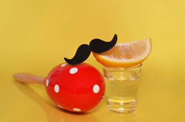 Tequila shot with mustache and red maracas on yellow background - obrazy, fototapety, plakaty