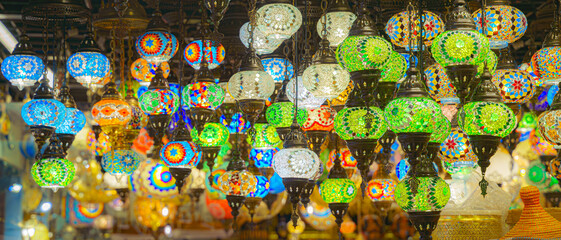A view from below of a variety of many colorful vintage Arabic and Persian lamps and chandeliers,...