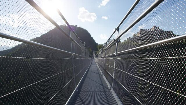 POV Walking across a highline suspension Bridge in the Alps with a scenic view