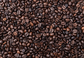 Closeup, top view of coffee beans over rustic wooden table