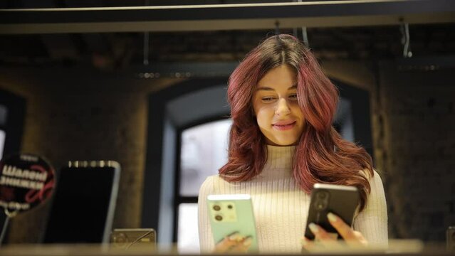 Close-up of a cute girl with beautiful hair picking up the phone on a dark background.