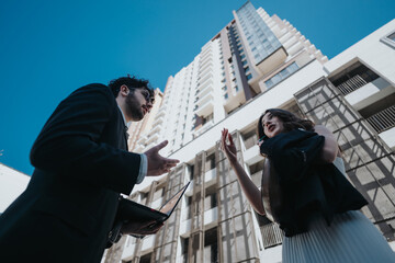 Two business professionals engaged in an animated conversation with city skyscrapers in the background.